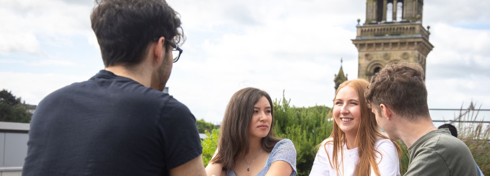 students sitting chatting on rooftop of one elmwood